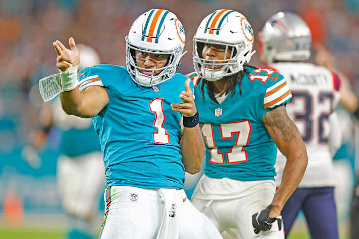 As teammate Jaylen Waddle celebrates, Tua Tagovailoa points for a first down during a season-ending win over the Patriots.
